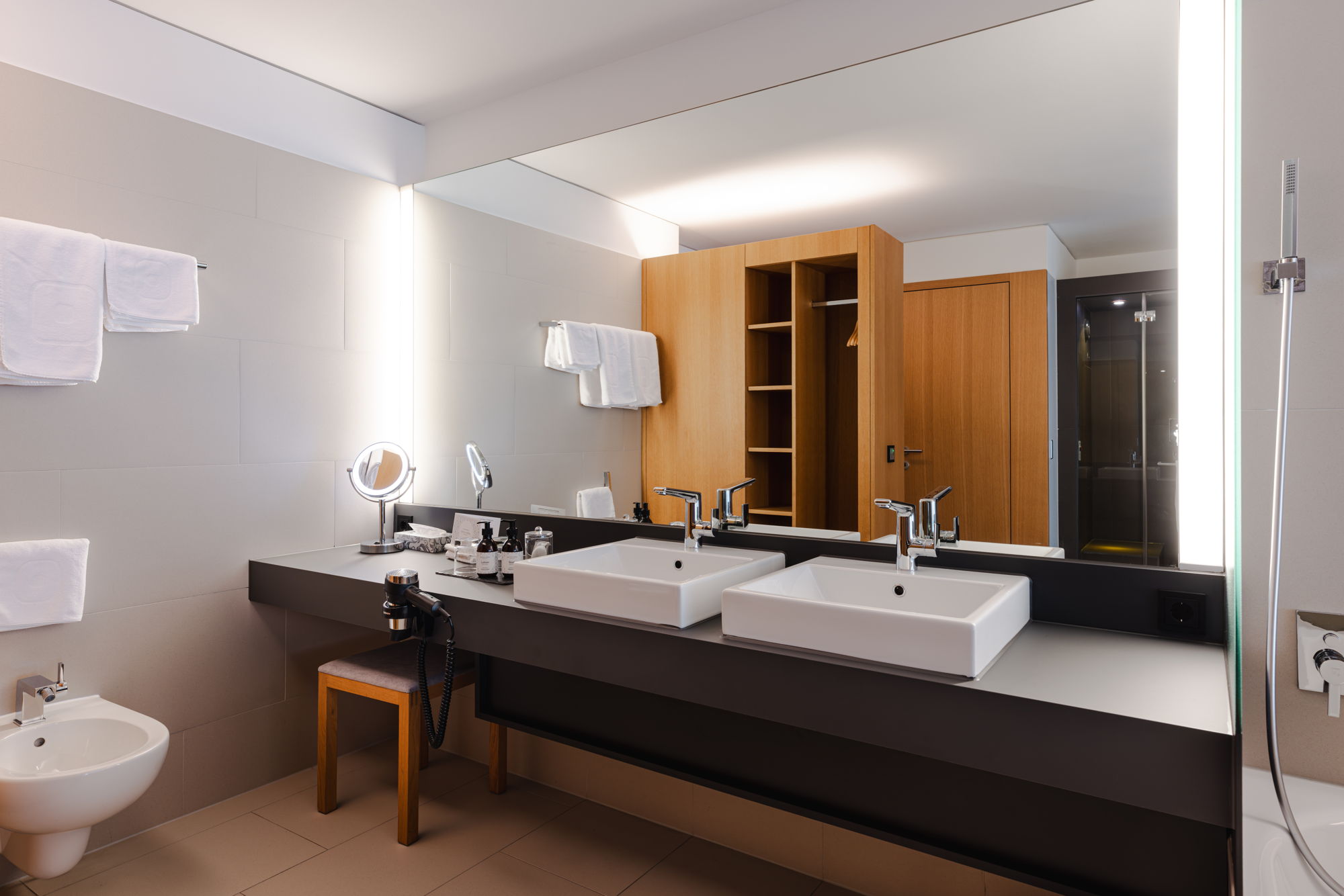 Modernes Badezimmer der Feel good Suite mit Doppelwaschbecken und großzügigem Waschtisch