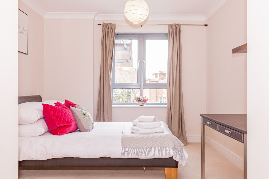 Bedroom with large double bed and extra linen