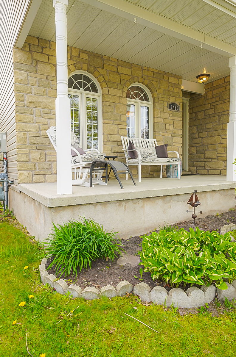 view of exterior entry with a yard and central AC