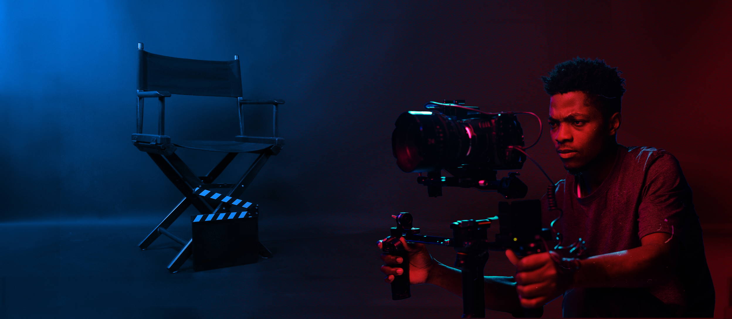 Black man filming a movie in dramatic lighting with a director's chair (large)
