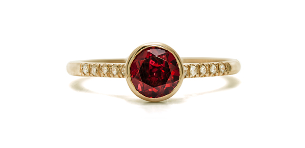 Gold ring with closed-set garnet and 10 pavé-cut diamonds.