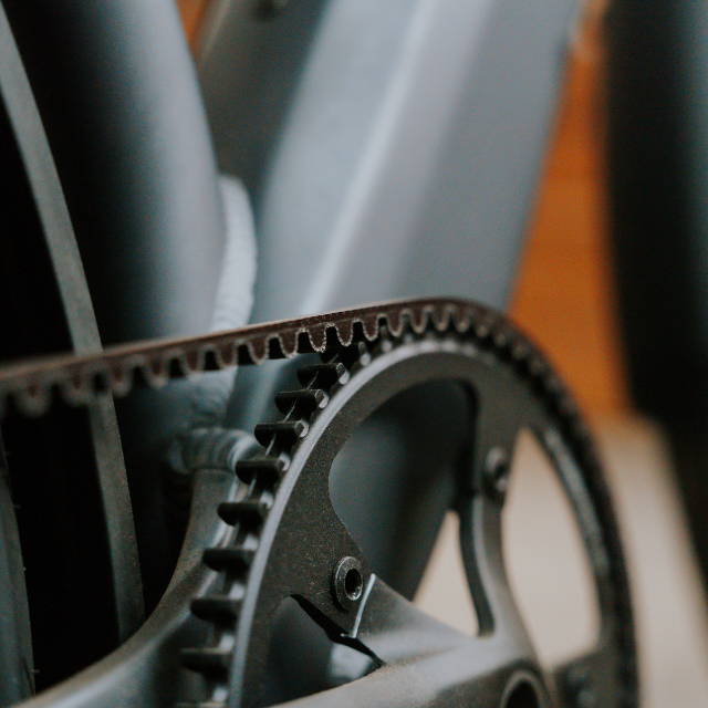 the closeup of the belt drive of a bike