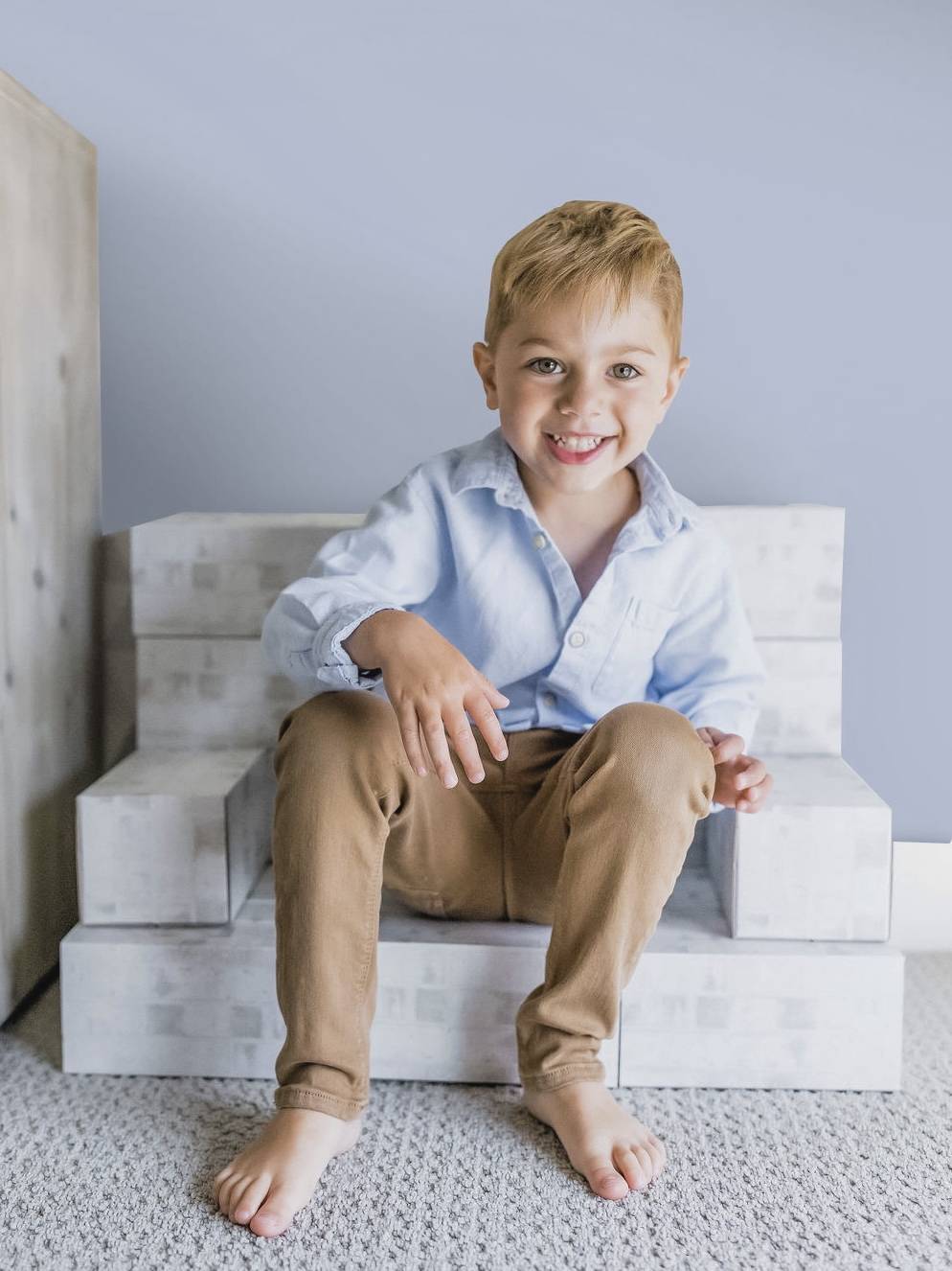 Boy sitting on white building blocks