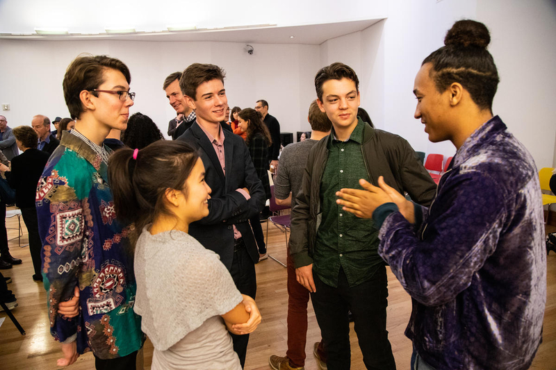 A group of LA Phil composer fellows stands around in a circle talking