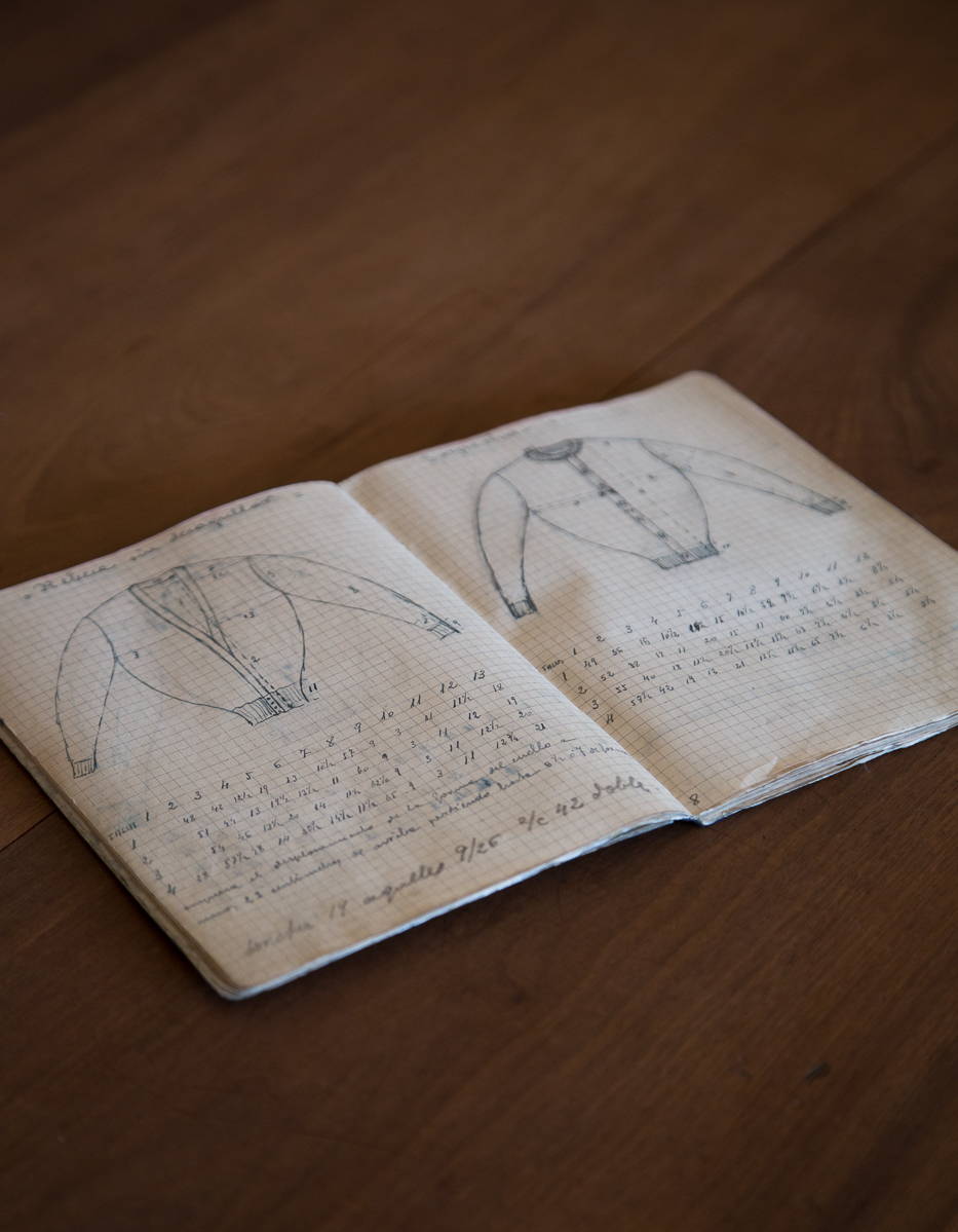 A very old notebook with pencil drawings of sweaters and handmade beads.