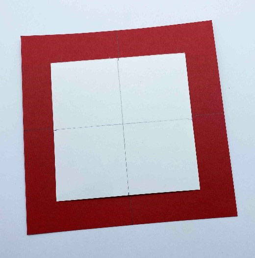 The white card is placed on the large red card in the centre to draw around