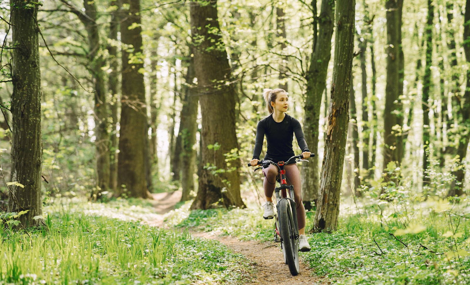 Une femme se promène en forêt avec son vélo électrique (VAE) ShiftBikes