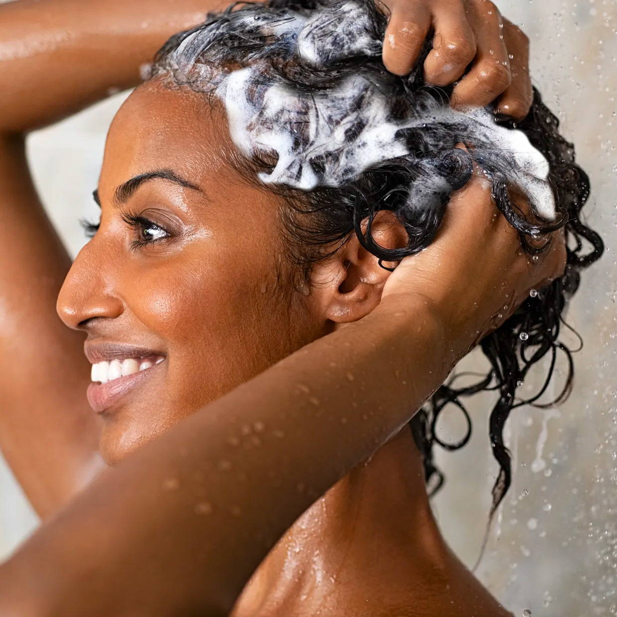 a woman with a darker skin tone washing her hair