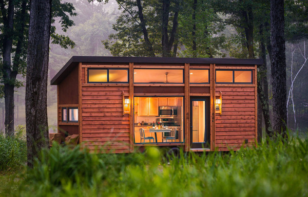 a tiny home is nestled away in the forest, oh how serene