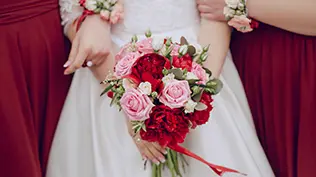 Gros plan sur la mariée tenant le bouquet de mariage avec les demoiselles d'honneur.