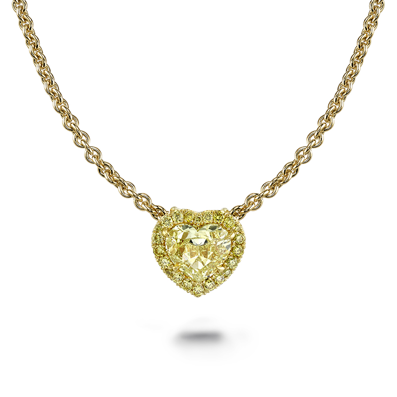 Heart shaped yellow diamond pendant necklace with yellow diamond halo on an 18k yellow gold chain.