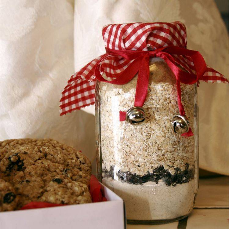 A large glass jar filled with oats covered with a red and white napkin tied with a bow