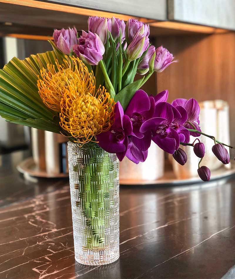 Cute bouquet of purples and Orange in a small vase