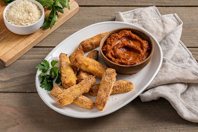 Baked cheese sticks with side of marinara sauce.