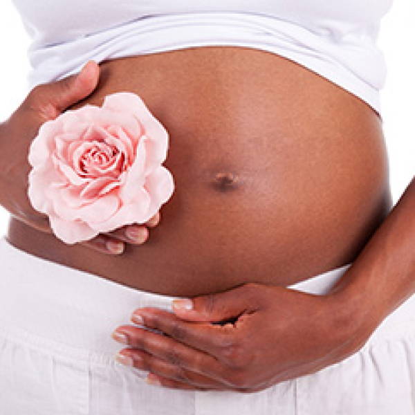 A pregnant woman's stomach with a rose on it
