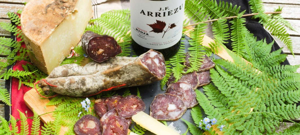 Fromage de brebis, charcuterie basque et vin sur une planche, produits de la BASK'BOX