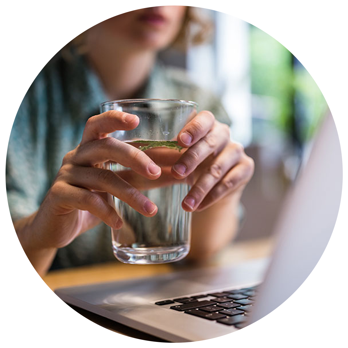 A person holding a glass of water showing inadequate water intake that can be avoided by taking elderberry gummies benefits