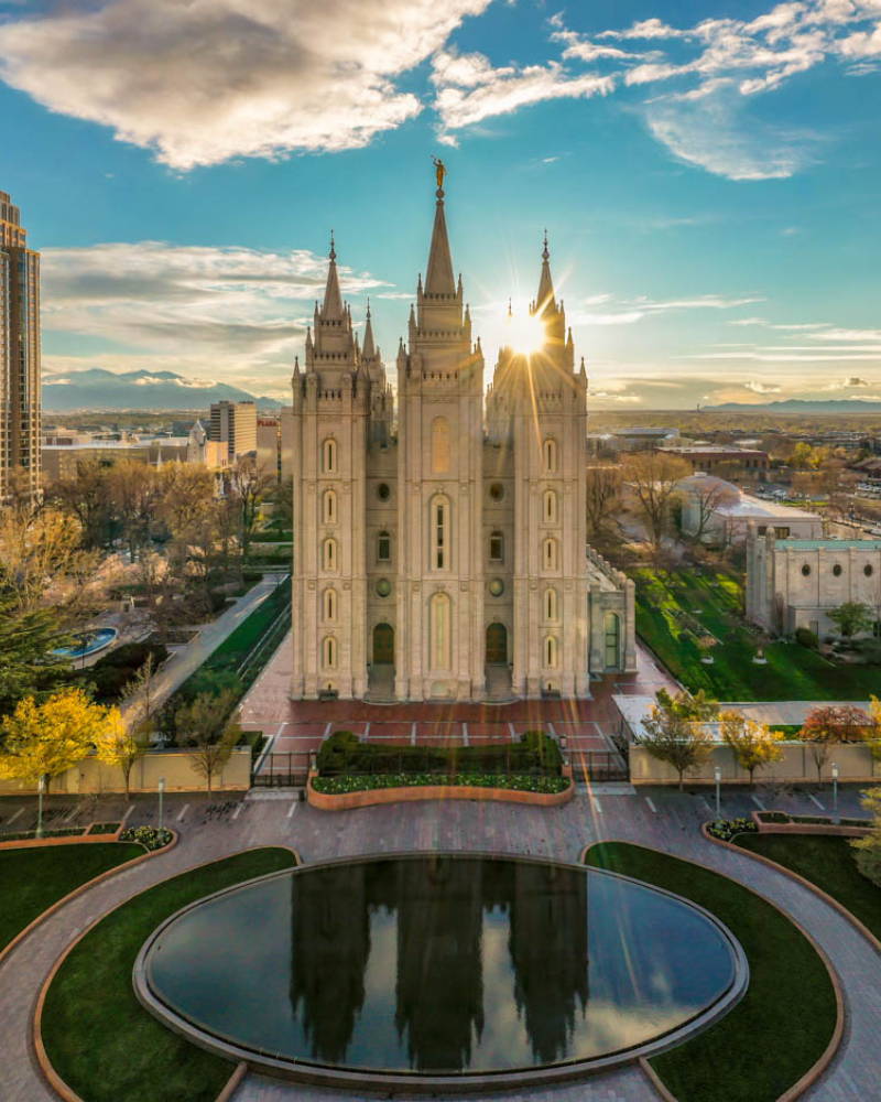 Aerial shot of the Salt Lake Temple reflected in a round pool. 