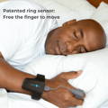 Man sleeping with Checkme O2 Max wrist oxygen monitor and ring sensor for overnight sleep tracking