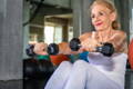 mature woman working out with small hand weights to help build collagen 