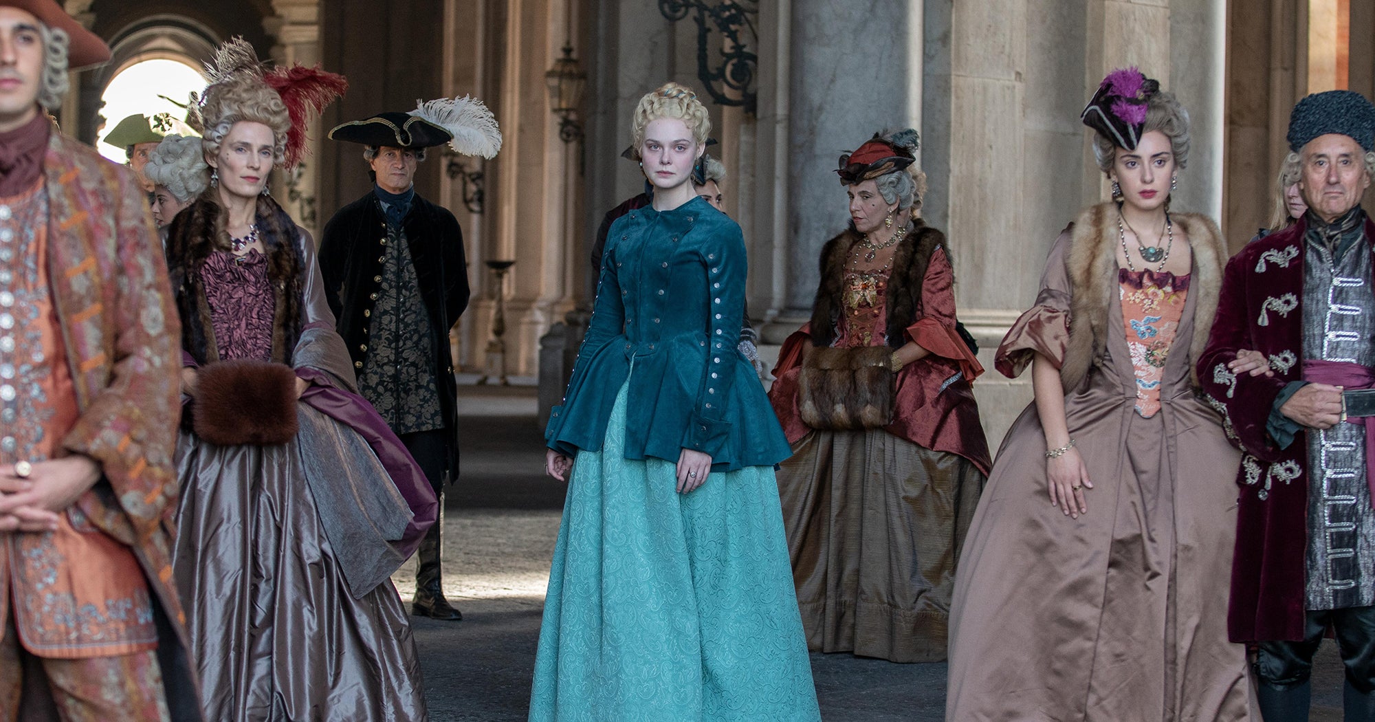 The cast of The Great all standing and looking at someone off camera with serious expressions.