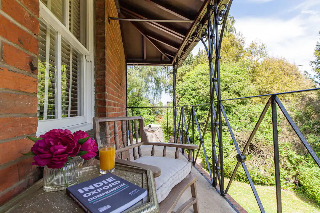 Balcony view from the property - Table with fruit juice and book facing trees and grass