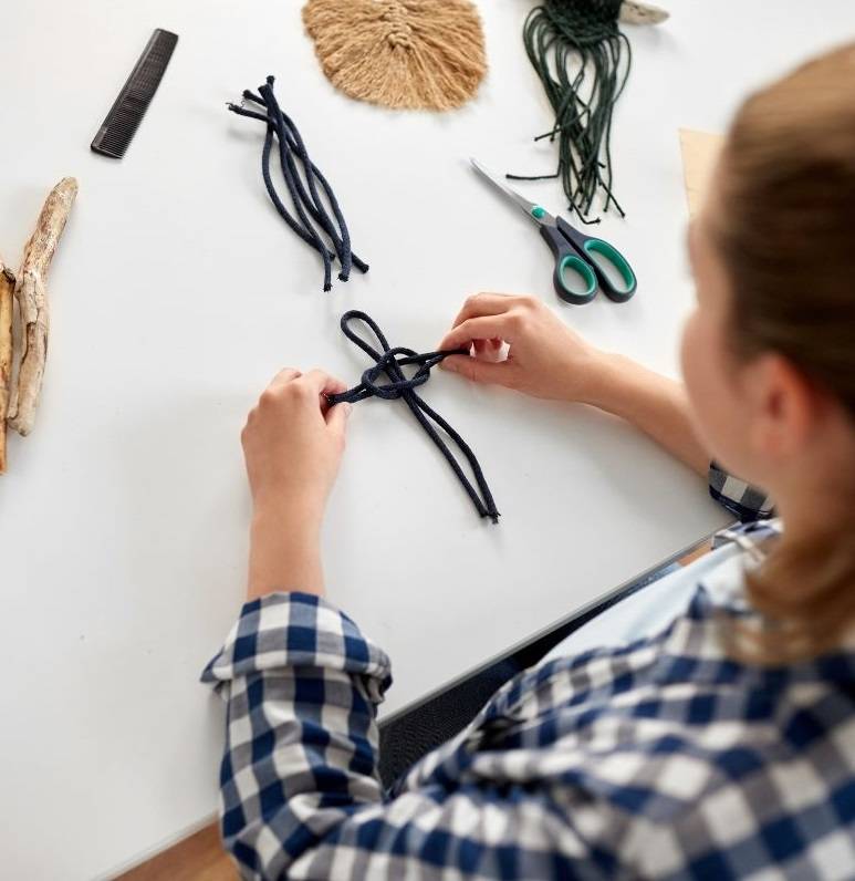 woman making macrame knots