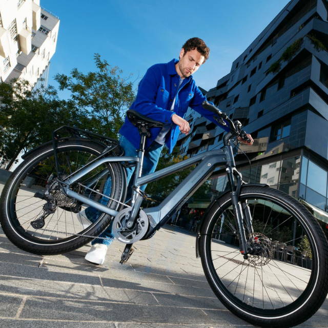 Man with electric bike on sidewalk