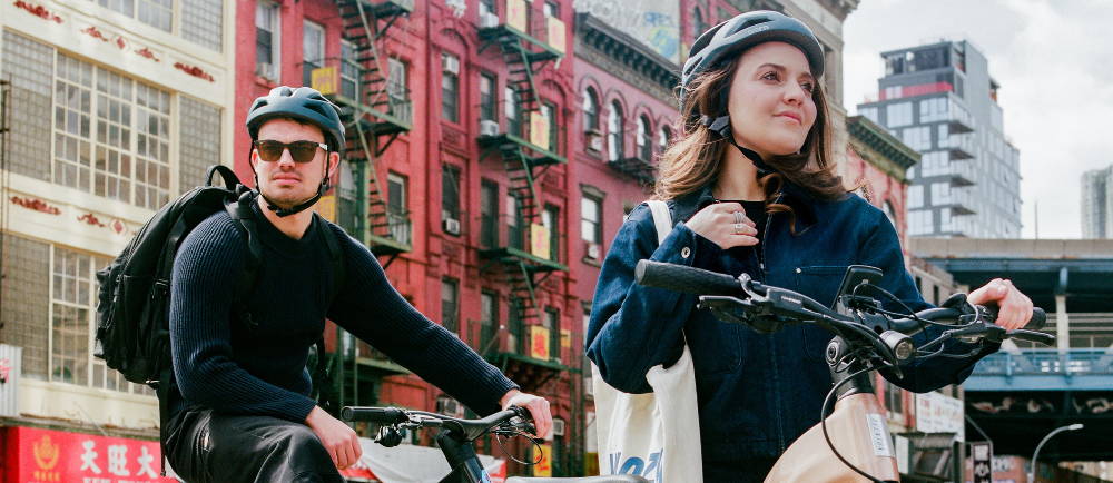 A couple sitting on their e-bikes in the street
