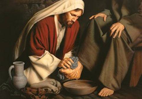 Jesus kneeling on the ground washing His one of His disciple's feet.