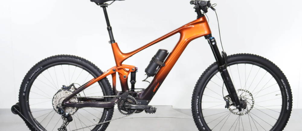 an orange Giant Trance X Advanced E+ 2 full suspension electric mountain bike