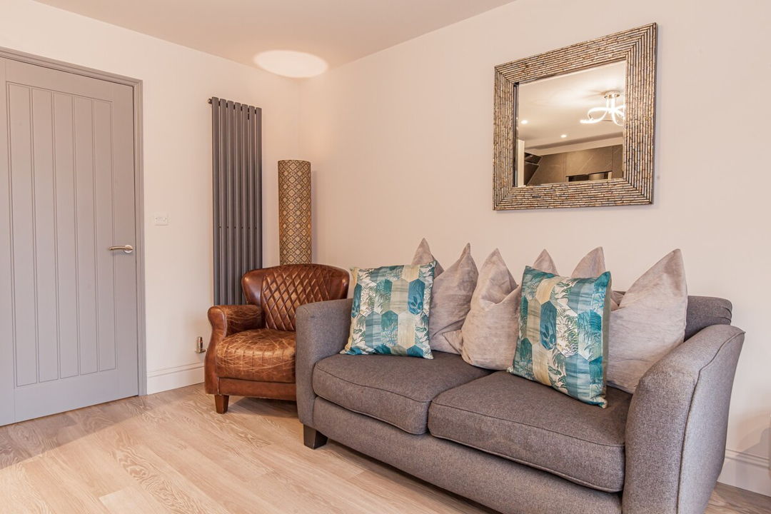 Large grey sofa with a pairing chair next to it within the living room