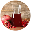 A bottle of Pomegranate Juice surrounded by the fruit, an ingredient in the best acv gummies
