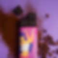 A partially unwrapped Fancis Premium Dark Chocolate bar (50% cocoa) on a purple background, with scattered coffee beans and cocoa powder.