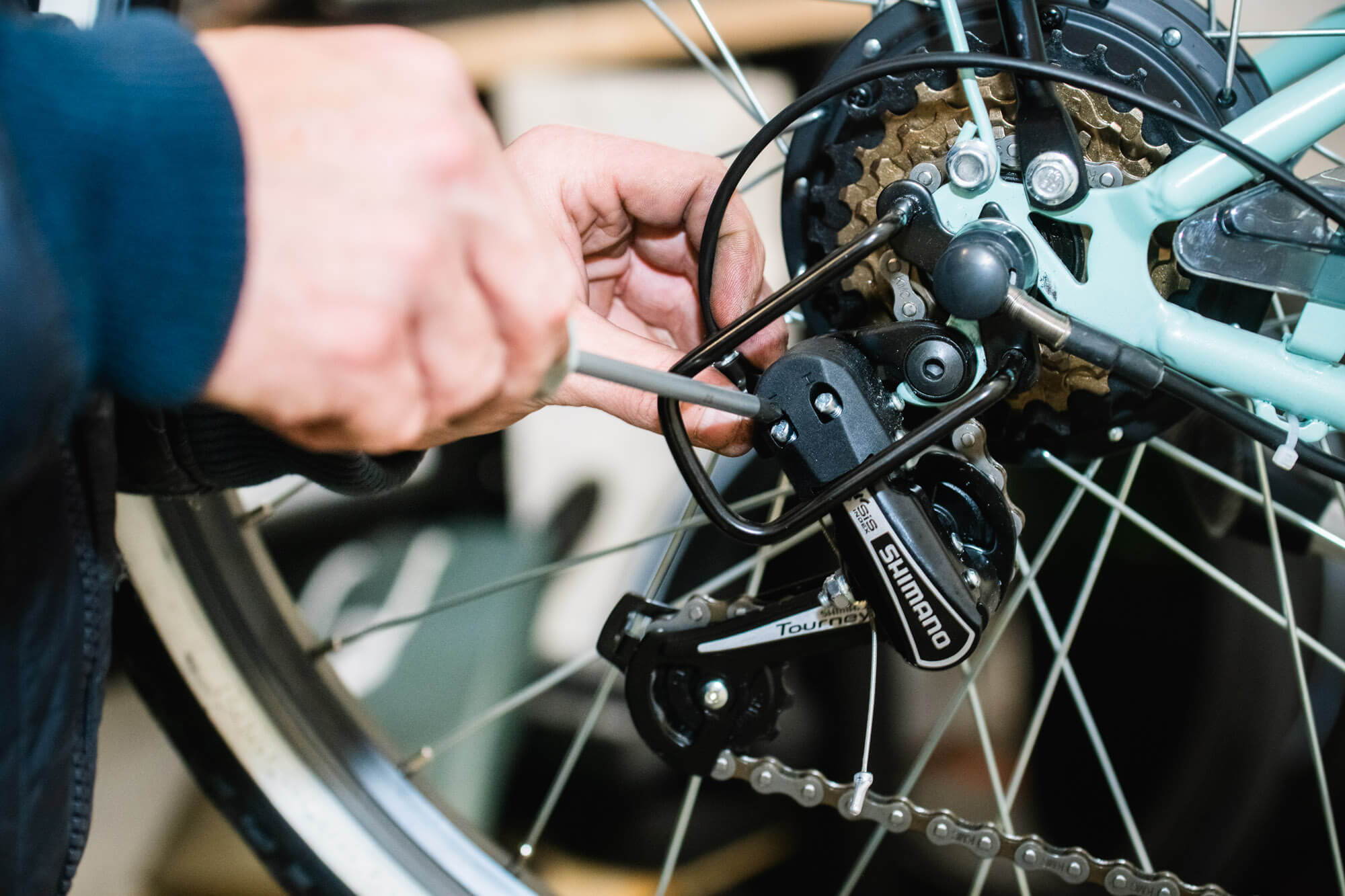 Main d'un cycliste en train d'électrifier son vélo grâce à un kit d'électrification.