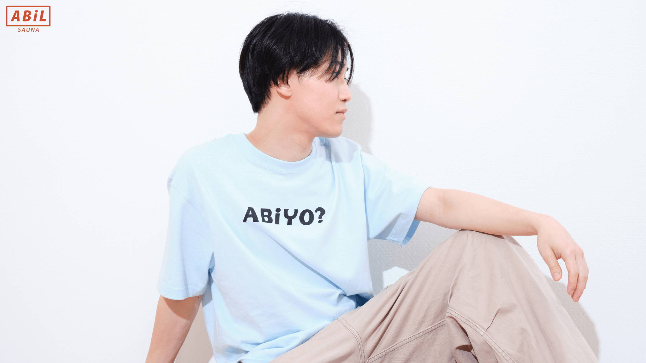 ABiYO?Tシャツを着てサウナ後のリラックス時間を過ごす男性モデル