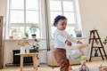 Toddler moving a bag filled with toys across the room.