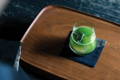 A glass of cold sparkling matcha on a tray
