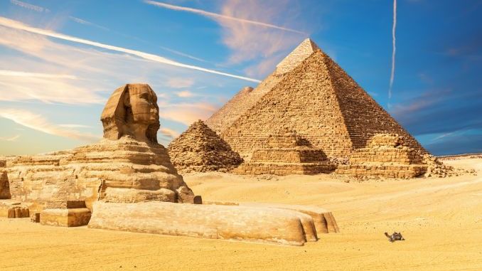 The Sphinx next to the Pyramids in the sands of Giza desert, Egypt