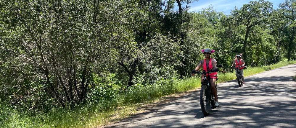 two people riding aventon aventure electric bike while on a paved road during a tour with Yosemite E-Biking (yosemiteebiking.com)