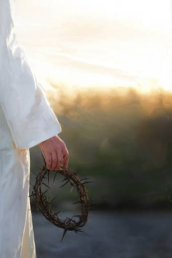 Jesus' hand holding a crown of thorns.