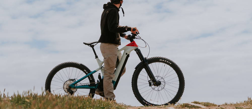 a man riding a Cannondale Moterra Neo Worth full suspension electric mountain bike near the ocean
