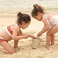 Two little girls playing with a silicone toy set at the beach.