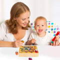 Mother and her little boy holding a yellow and blue bees while playing with wooden Montessori bee toy.