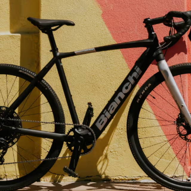 a bianchi eletric road bike in front of a multi colored wall