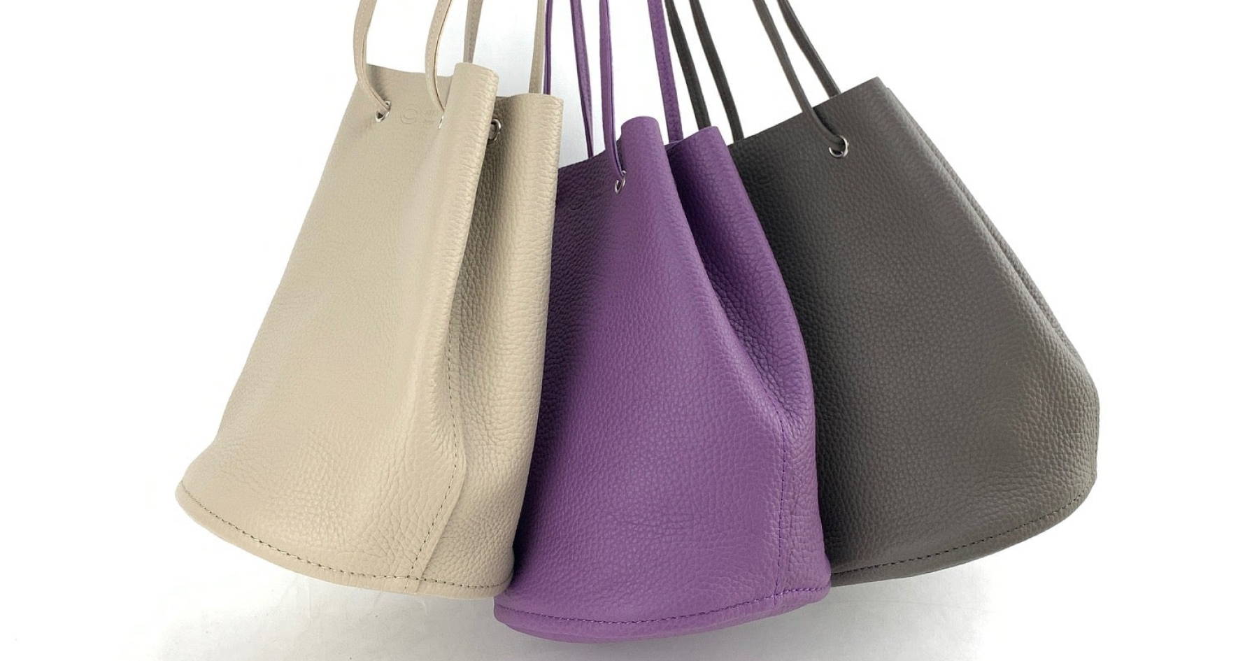 左から白、紫、トープの巾着ショルダーバッグが並んでいる。