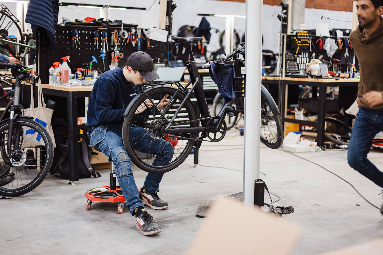 Cube Cargo bakfiets in zwarte uitoering met metallic elementen staand op grijze ondergrond en witte achtergrond