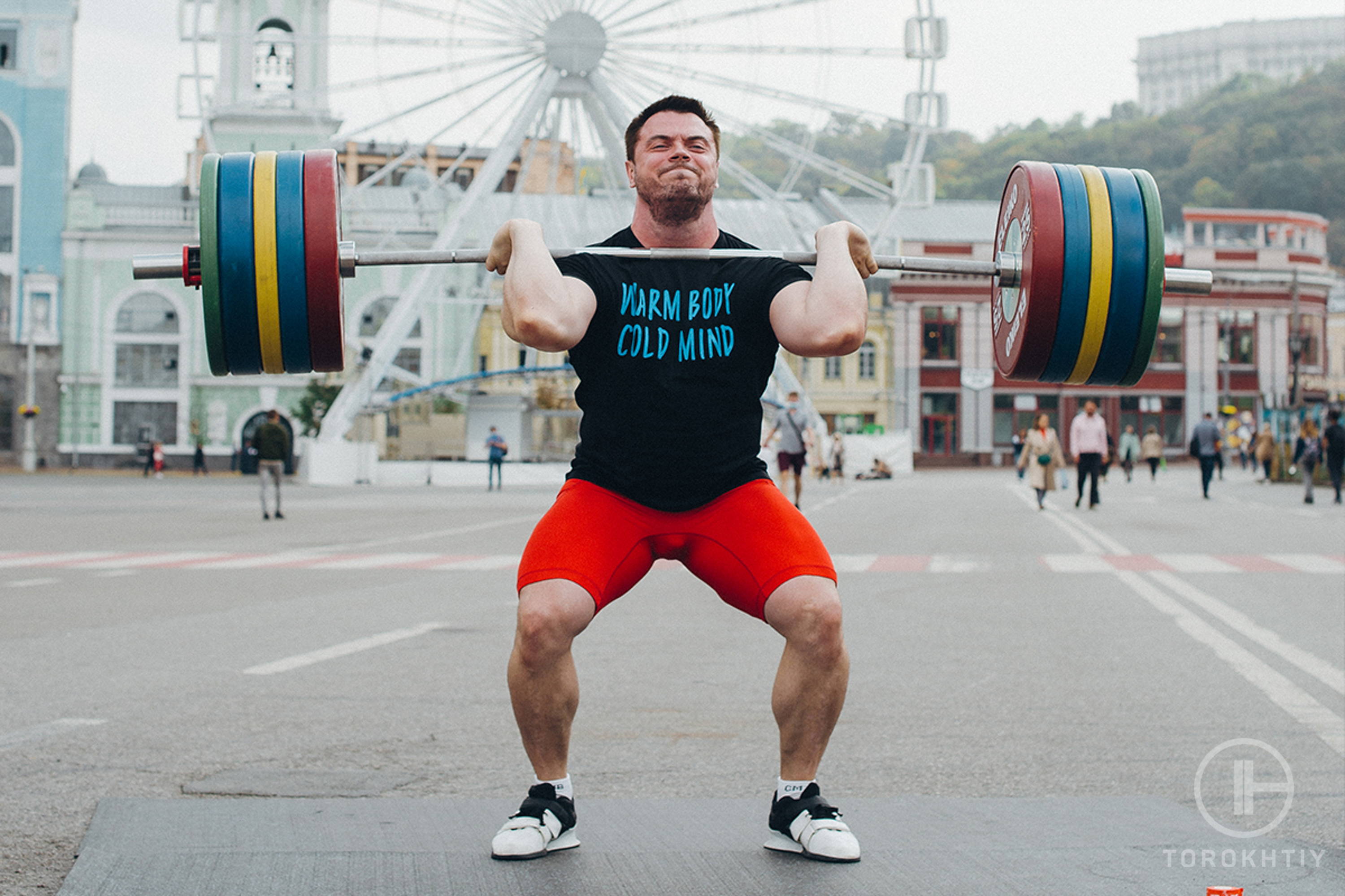athlete in red shorts powerlifting outdoors