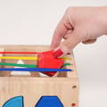 Blonde toddler sitting on the carpet and playing with a Montessori Switch Board.