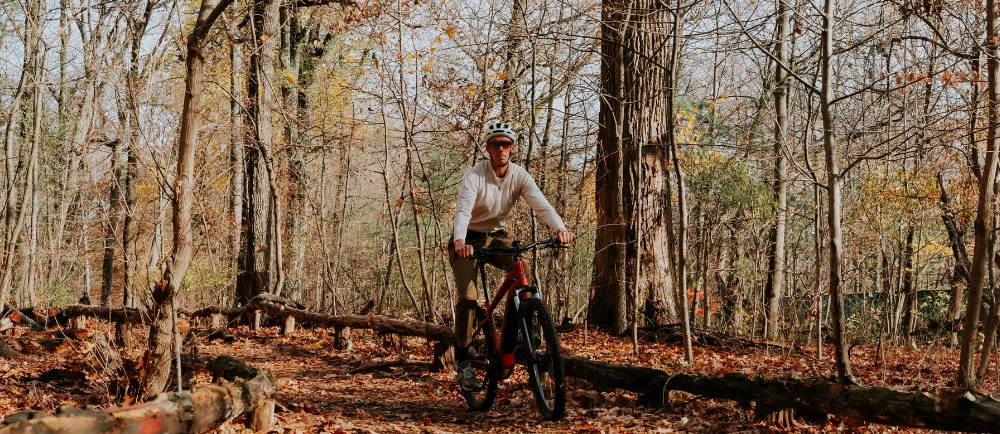 a man riding an electric mountain bike in the forest